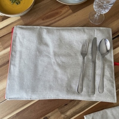 Mesa com sopa, pão, azeite, talheres e copo de água