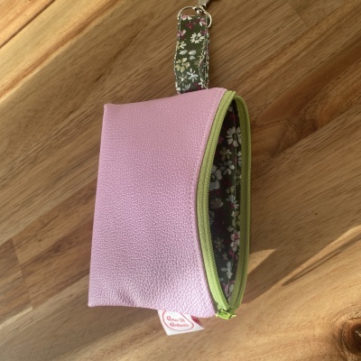 Estojo rosa com fecho verde e interior floral