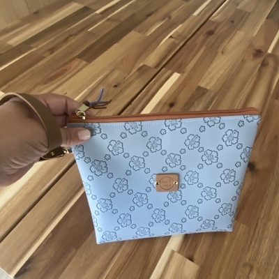 Mala azul clara com padrão de flores e etiqueta Ana B Artesã