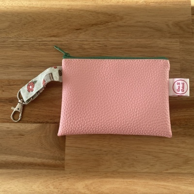 Bolsa rosa com fecho verde, pega florida e etiqueta Ana-R Artesan