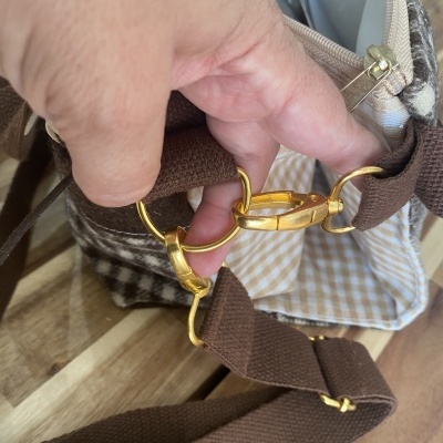 Saco tecido castanho com padrão xadrez e detalhes dourados