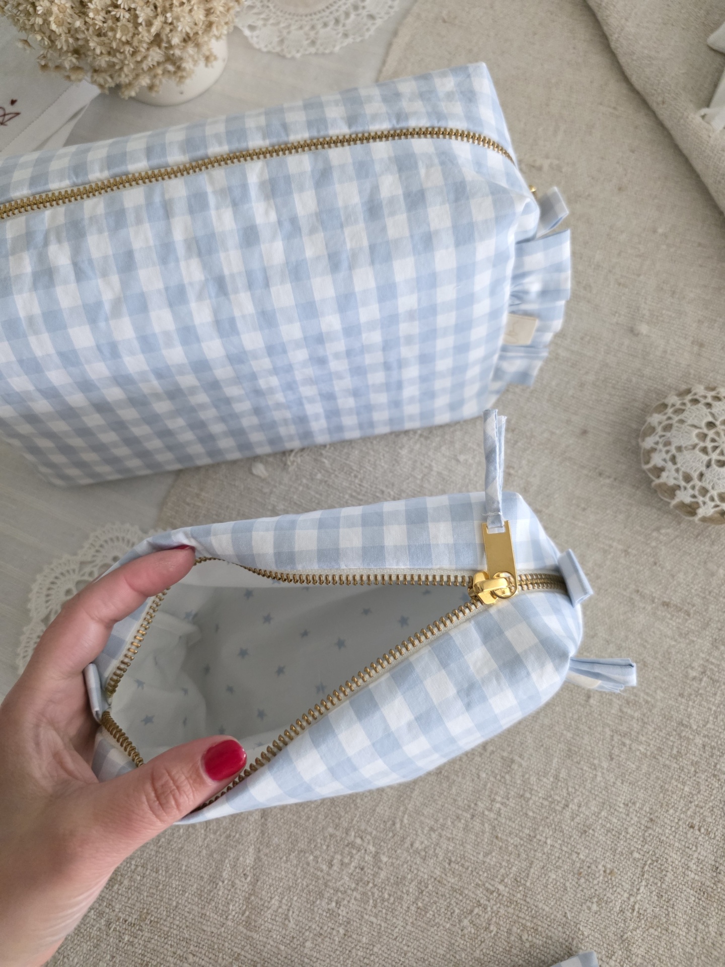 saquinho necessaire Necessaire azul e branca xadrez com fecho dourado e interior com estrelas azuis