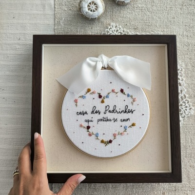 Quadro bordado com mensagem em português e laço branco