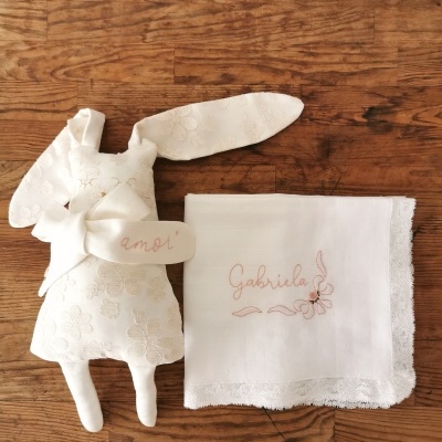 Boneco de tecido branco com padrão floral e lenço branco bordado