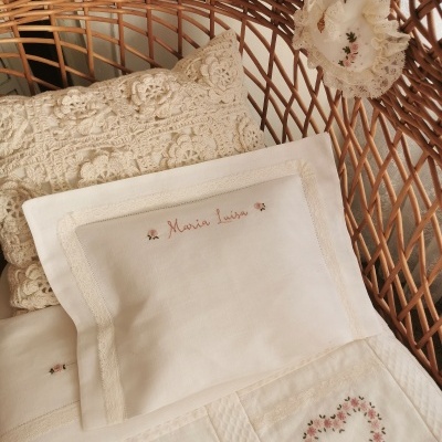 Berço de vime com almofada de crochê e fronha bordada com nome