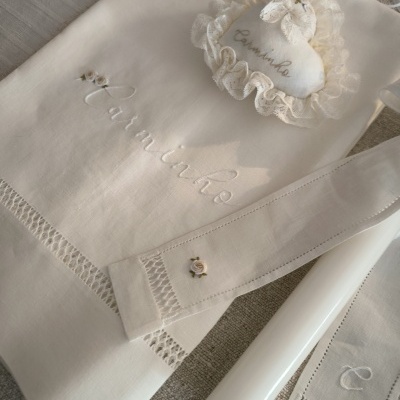 Conjunto de tecido branco bordado com o nome Jasmine e vela branca