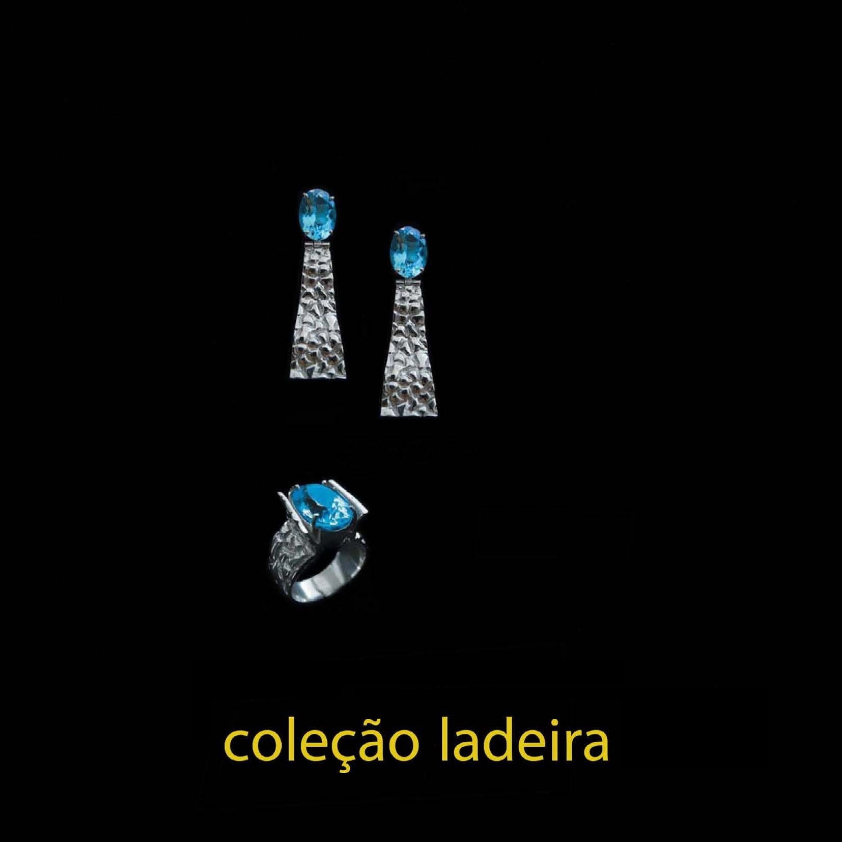 Anel Ladeira Conjunto de brincos e anel prateados com pedras azuis sobre fundo negro