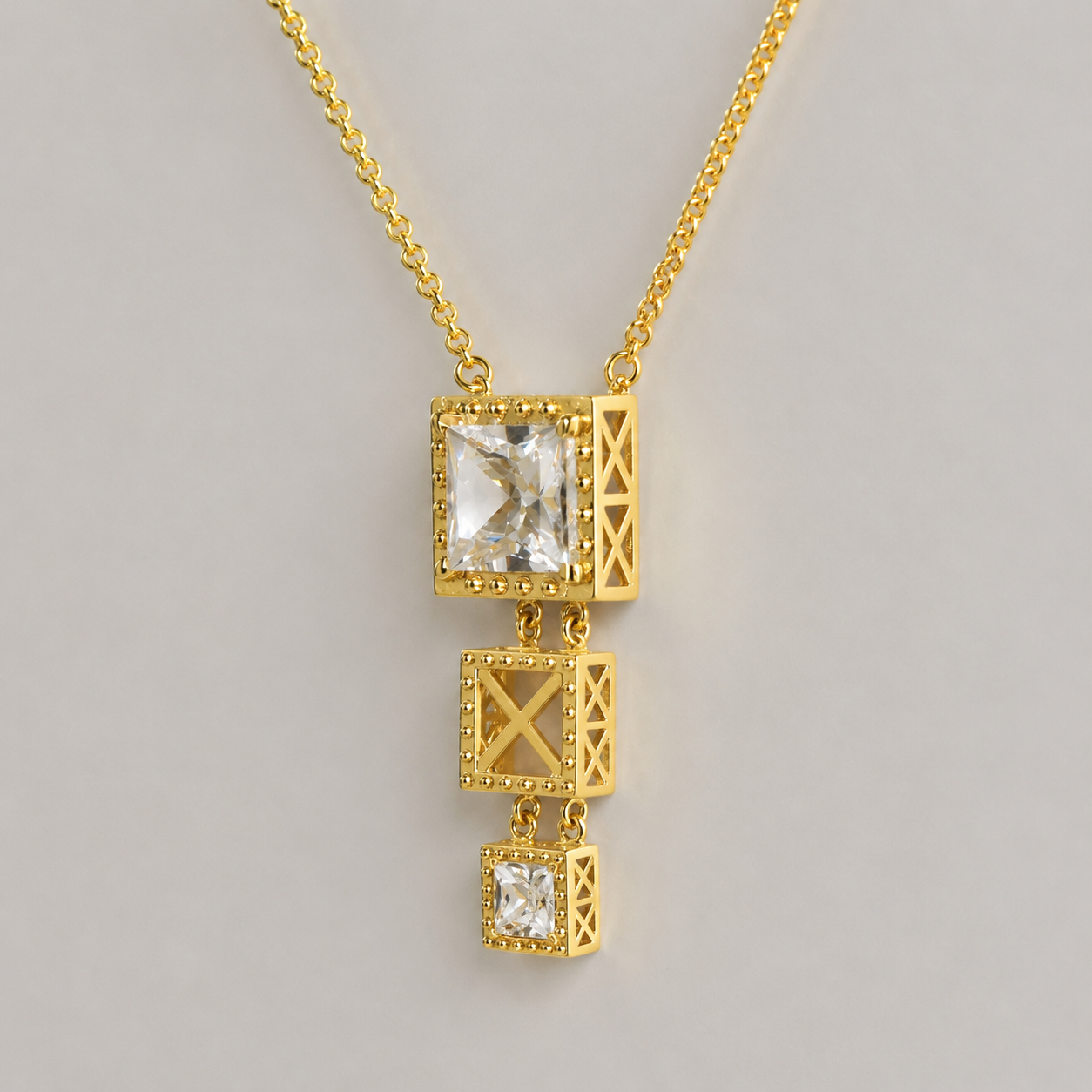 Colar Ponte 3 Colar dourado com pendente de três cubos decorativos e pedras claras