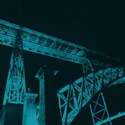 Ponte metálica iluminada a azul à noite