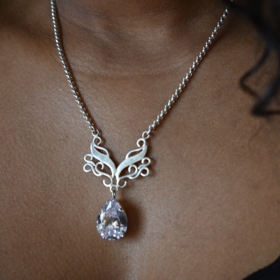 Colar prateado com pendente decorativo e pedra em gota transparente