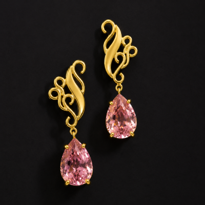 Brincos dourados com pedra rosa em fundo preto