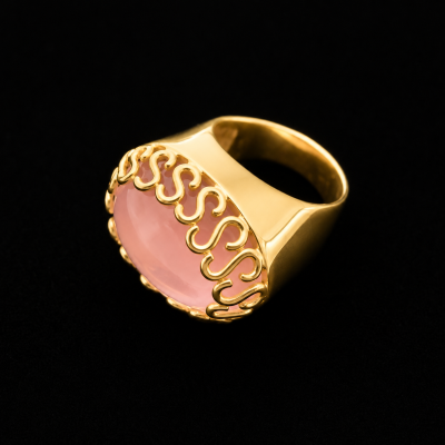 Anel dourado com pedra rosa e detalhes decorativos