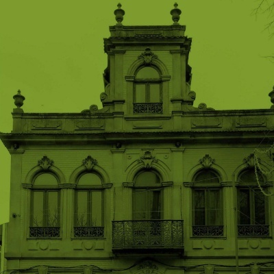 Fachada de edifício antigo com janelas arqueadas e varandas de ferro