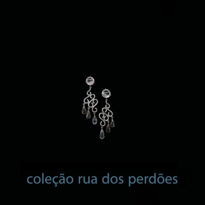 Brincos pendentes prateados com pedras transparentes em fundo preto