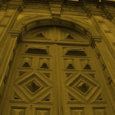 Portal de madeira trabalhada castanha-amarelada com detalhes geométricos