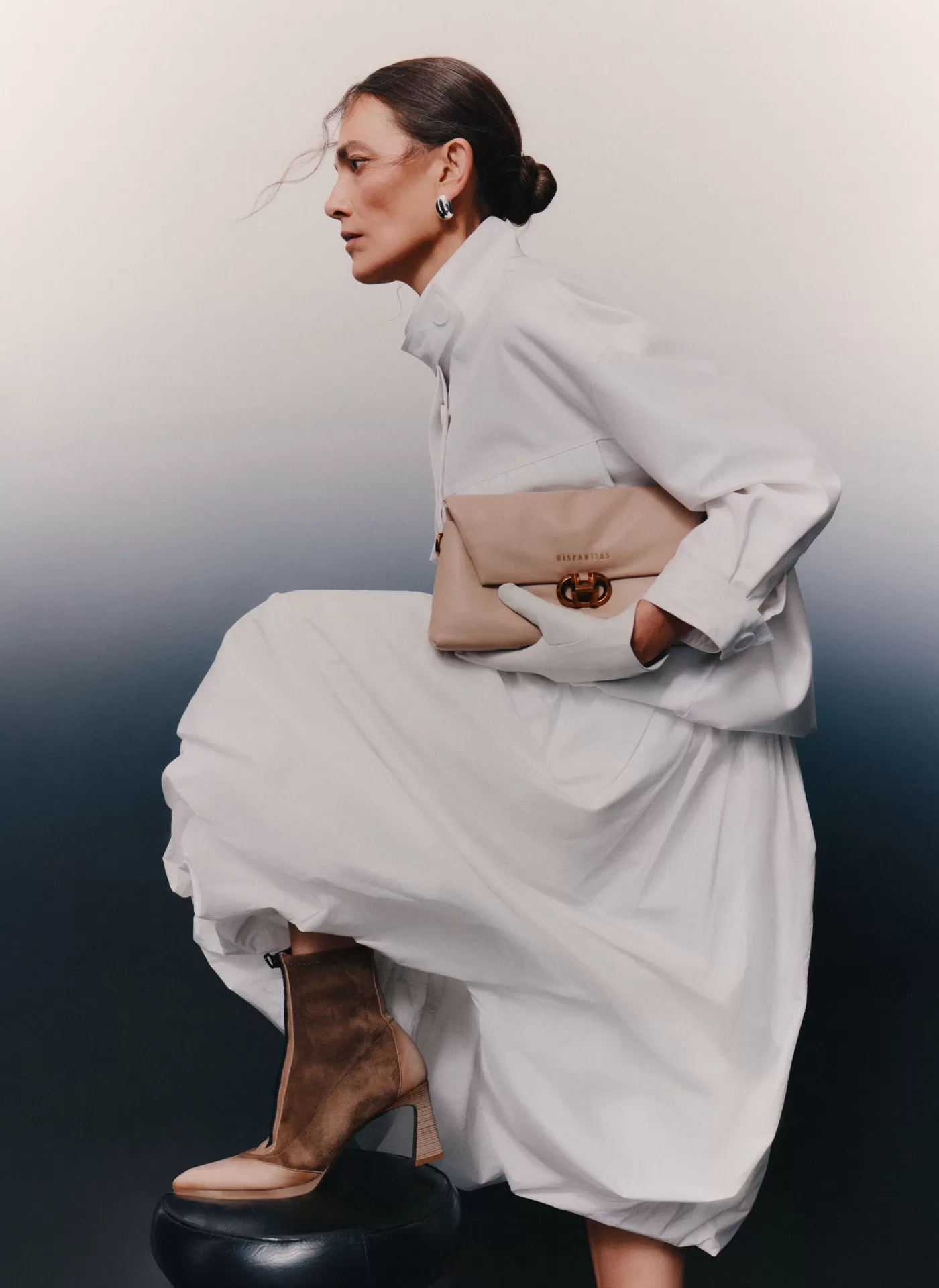 Botim Hispanitas HV254186 Taupe Mulher vestida de branco com botas castanhas e bolsa bege com fecho metálico