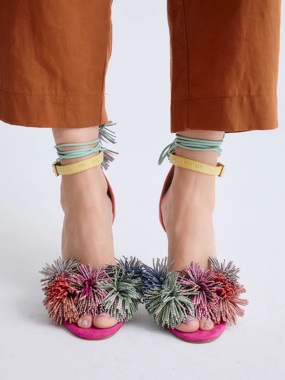 Sandálias Exé JENIFER-725 Mult. Sandálias femininas rosa com pompons coloridos e tiras amarelas com brilho junto a calças castanhas