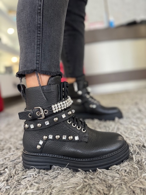 Bota Estilo Militar ABF-97 V032-156-1 Bota preta de couro com atacadores e tachas prateadas num tapete cinza