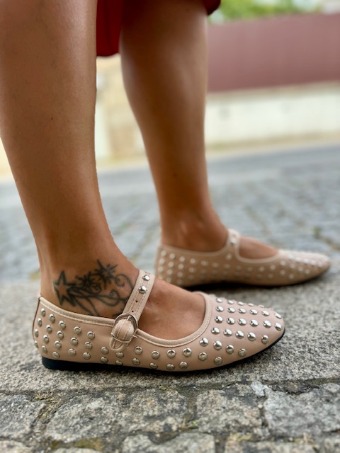 Sabrinas ExéM14-03 Bege Sapatilhas cor de pele com tachas e fivela, usadas por pessoa com tatuagem no tornozelo