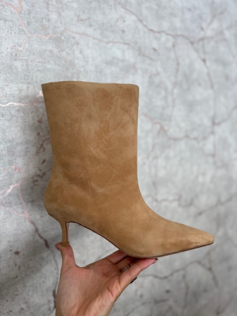 Botim ABF.97 V1525-35-3 Bota camel de camurça com salto fino sendo segurada por uma mão