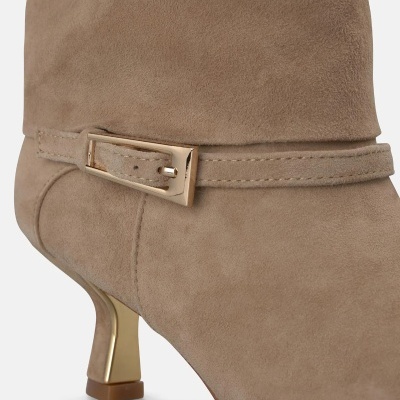 Bota feminina bege de camurça com salto dourado e fivela.