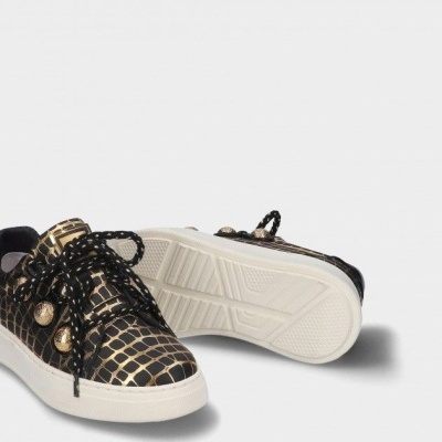 Ténis pretos e dourados com padrão crocodilo e sola branca