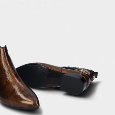 Botins castanhos brilhantes com tacão preto e detalhes metálicos