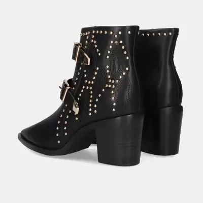 Botas pretas com tachas douradas e fivelas em fundo branco