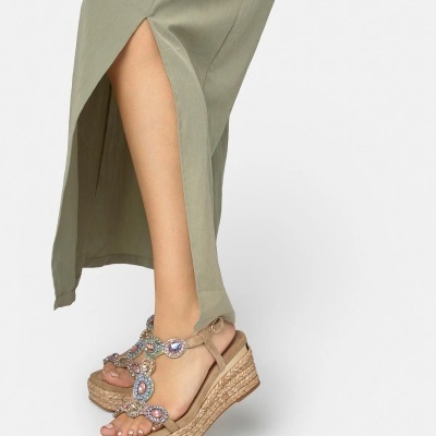 Sandálias tipo cunha com pedras coloridas e saia verde clara