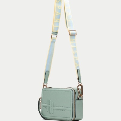 Mala de ombro verde-água com alça branca e amarela e símbolo em relevo