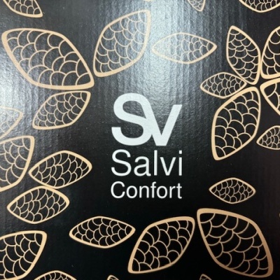 Embalagem preta com padrão de folhas douradas e texto 'SV Salvi Confort'