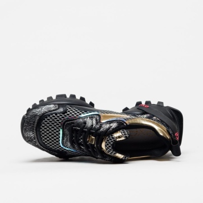 Ténis desportivos pretos com detalhes dourados e sola preta texturada