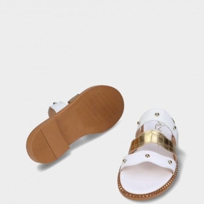 Sandálias brancas com detalhe dourado e rebites em fundo branco