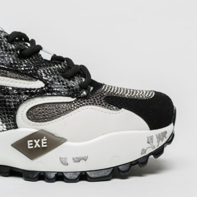 Ténis desportivo preto e branco com etiqueta EXÉ e sola grossa