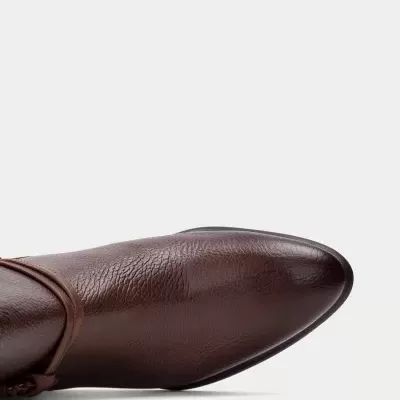 Bota castanha de couro com bico fino sobre fundo branco