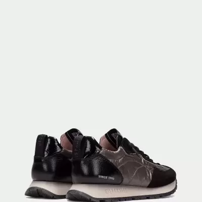 Sapatilhas desportivas cinza e preto com sola bege e texto 'SINCE 1990'