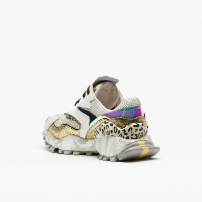 Tênis feminino branco com detalhes dourados, holográficos e padrão animal print e sola com risca amarela.