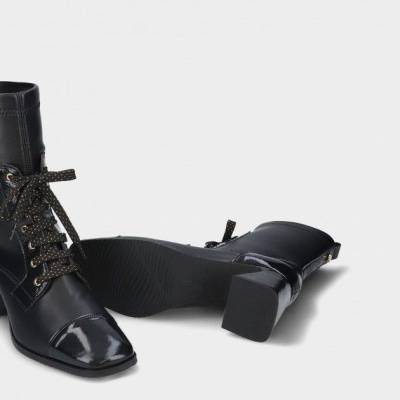 Botas pretas de cano médio com atacadores brilhantes em fundo branco