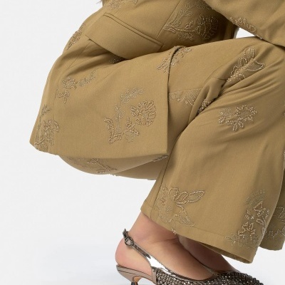 Sapatos de salto médio com strass prateados e calças camel bordadas