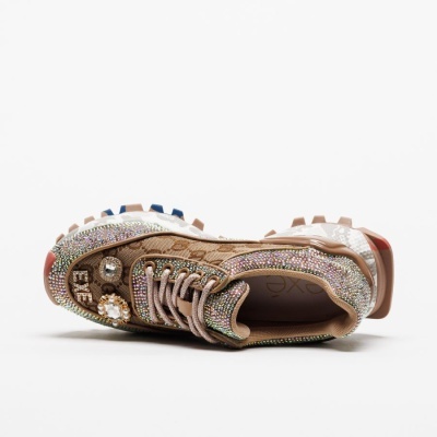 Ténis castanho com detalhes brilhantes e pedras decorativas de lado
