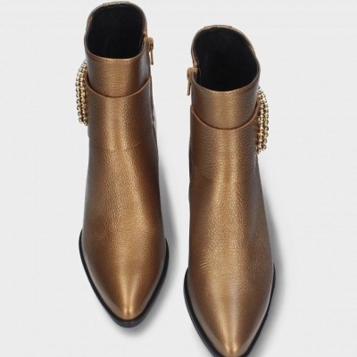 Botas metálicas bronze com correntes douradas, vista superior