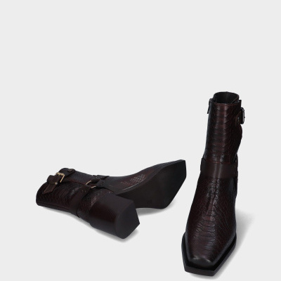 Botas castanhas de cano curto com textura de escamas e fivelas metálicas
