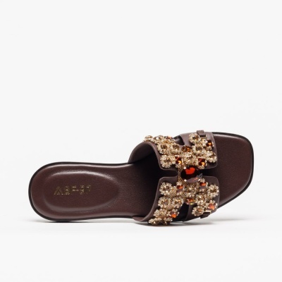 Chinelo castanho escuro com pedras brilhantes douradas e âmbar.