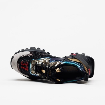 Tênis desportivo camuflado com detalhes azuis metálicos e número 37 vermelho.