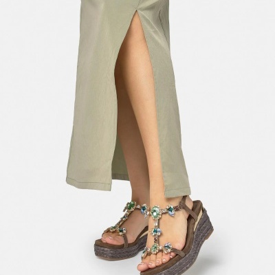 Sandálias de cunha castanhas com pedras coloridas e saia bege com racha