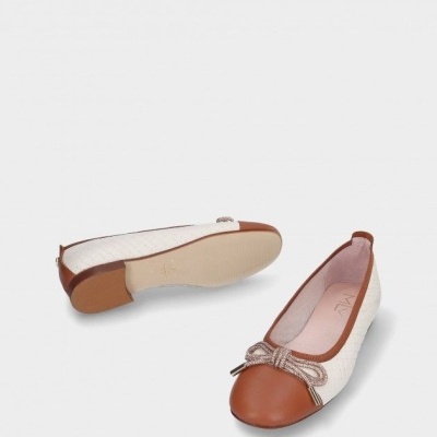Sapatilhas femininas castanhas e brancas com laço decorativo sobre fundo branco