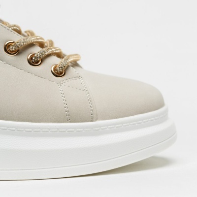 Ténis bege claro com sola branca e atacadores dourados
