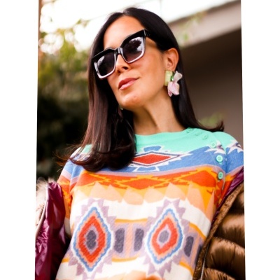 Mulher com óculos de sol e camisola colorida com padrão geométrico