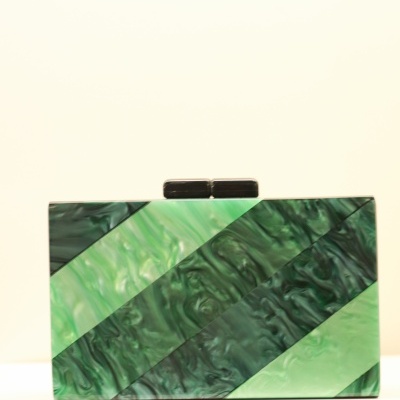 Bolsa clutch retangular verde com padrão marmoreado e fecho preto