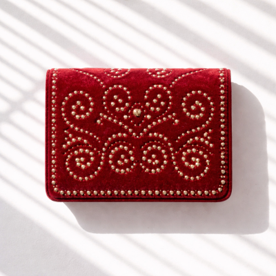 Carteira vermelha em veludo com tachas douradas decorativas